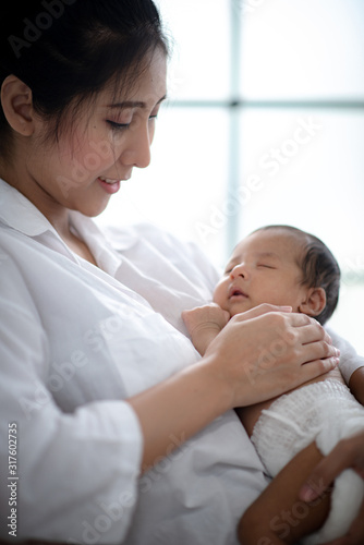 Asian parent hands holding newborn baby fingers, Close up mother's hand holding their new born baby. Love family healthcare and medical