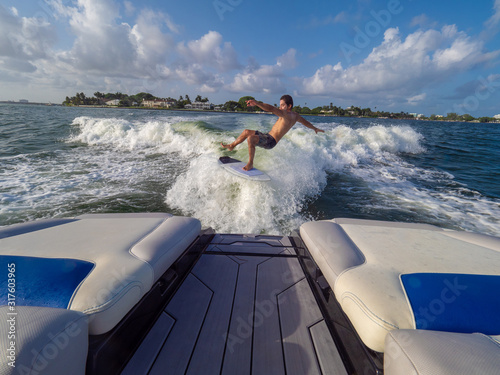 Athletic male falls from board while wakesufing at sea photo