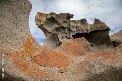 Remarkable stones with orange lichen. View from a xenolith hole on another rock and blue sky. photo