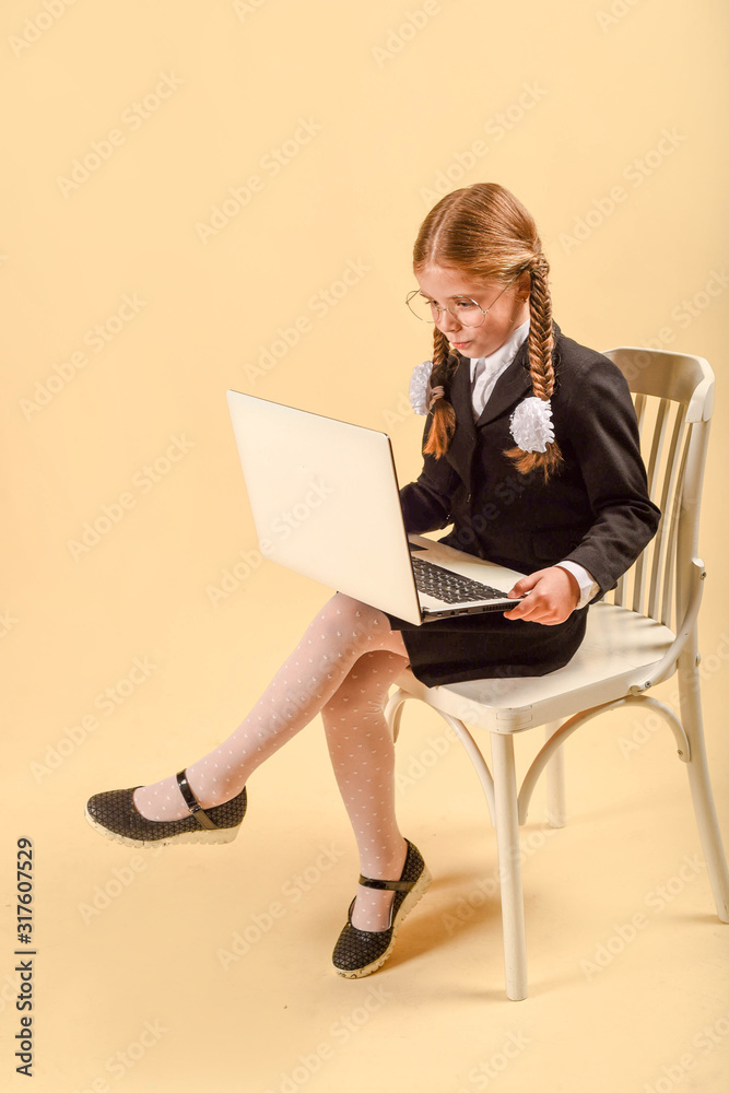Schoolgirl with a laptop in the studio. Business woman in a business suit. Online work. network work. Schoolgirl with a laptop in the studio. Business woman in a business suit. Online work. network work.