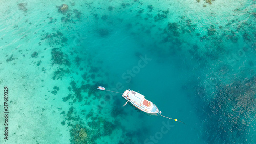 Boat anchored on the coral reef, aerial view from drone © jovannig