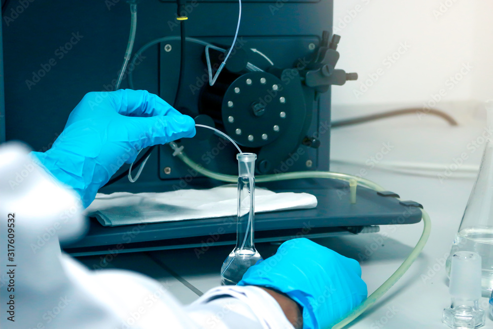 Research scientist hand with blue chemical protective gloves using ...