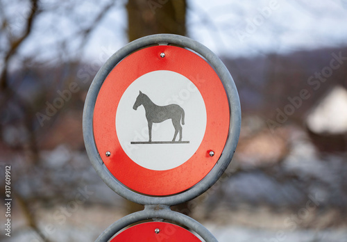 red and white horses prohibition sign in front of blurred background