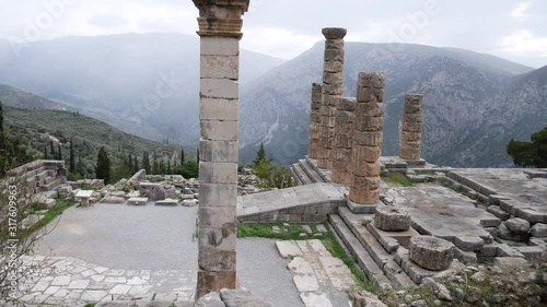 Delphi, Grece, Europe - dicember 30 2019: turists visit the ruins of the ancient temple of Apollo, archaeological site of Delphi along the slope of Mount Parnassus, UNESCO World Heritage, Greece. photo