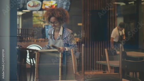 Cheerful small business owner preparing restaurant for opening in morning