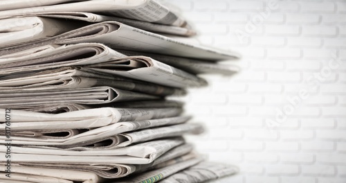 Pile of newspapers on white wall background