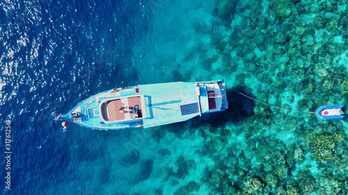 Overhead aerial view of boat exploring coral reef