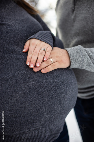 hands of man and women on pregnant belly