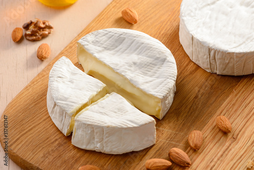Close up on a Camembert cream cheese and almonds on a cutting board