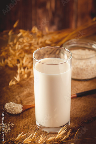 Super Food - A glass of oat milk for a healthy diet. Trending food, vertical photo. Place for your text.