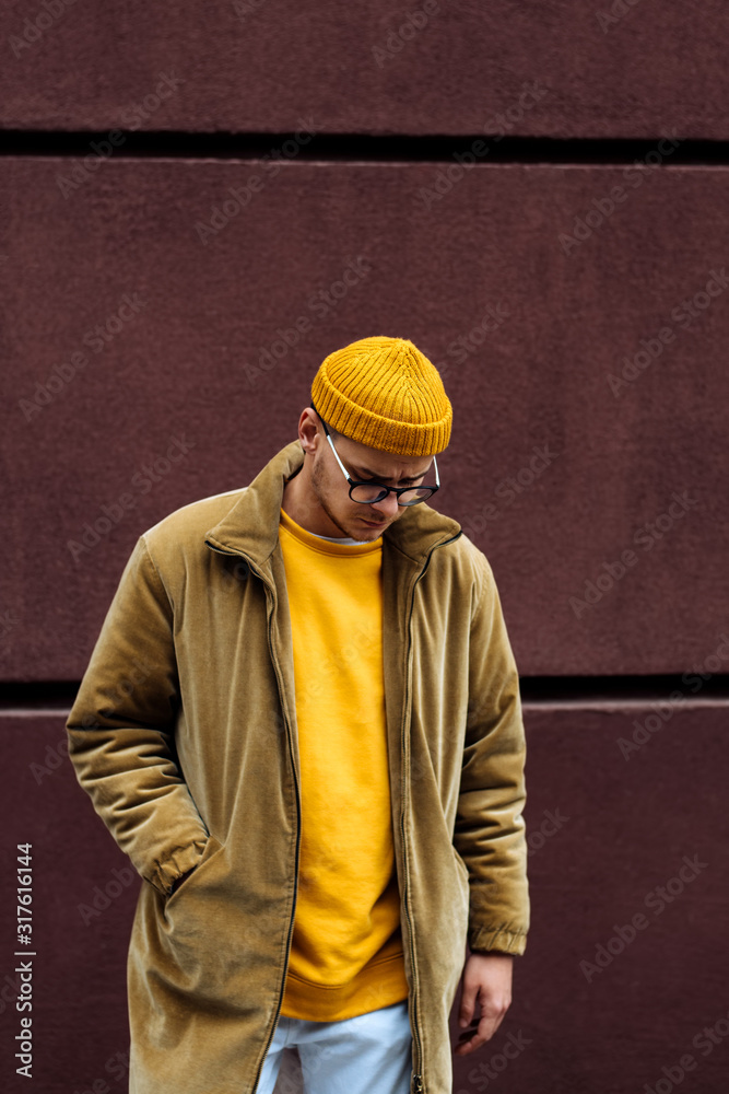 Photo of a young fashion stylish trendy look man model  in color clothes modern style outdoor street style  natural light