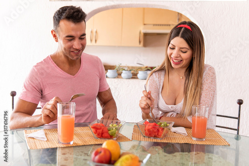 Pregnat couple having a light breakfast.