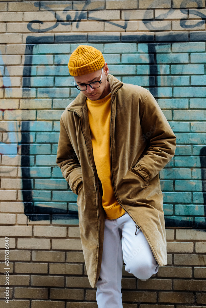 Photo of a young fashion stylish trendy look man model  in color clothes modern style outdoor street style  natural light - obrazy, fototapety, plakaty 