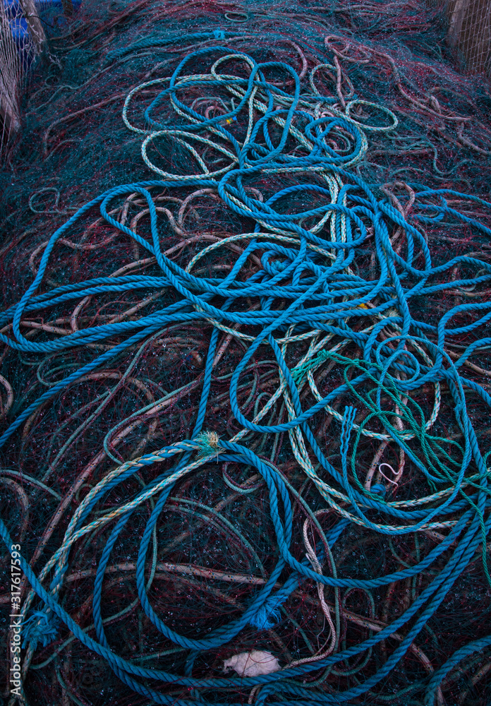 close up on Pile of tangled ropes and various fishing nets on a dock close up on Pile of tangled ropes and various fishing nets on a dock