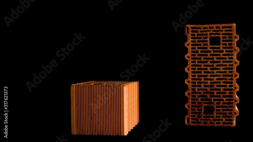Close up of two orange bricks isolated on black background. Stock footage. Building and construction materials concept, photo