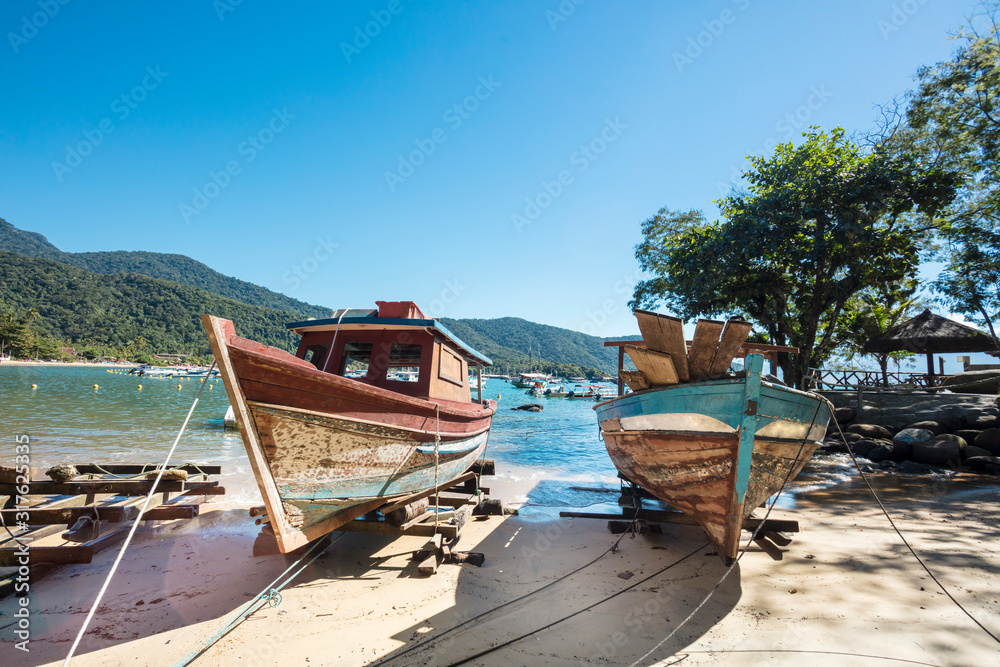Boats anchored at Praia de Abraaozinho with taxi boat and blue waters in Abraao, on the tropical Ilha Grande, Angra dos Reis, in the south of Rio de Janeiro Brazil