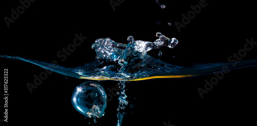 water waves with beautiful bubbles on a black background. © Montri