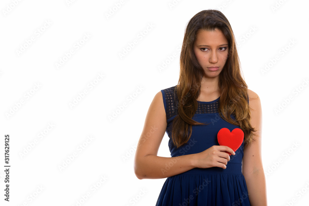 Portrait of sad young woman holding heart while looking down Portrait of sad young woman holding heart while looking down