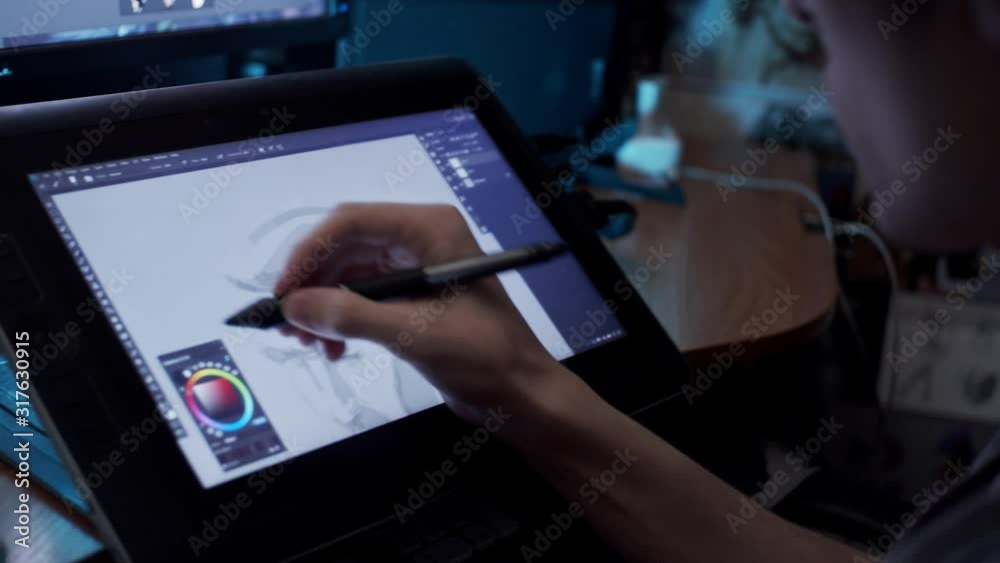 Young artist drawing illustration on tablet, slow motion, shallow depth of field
