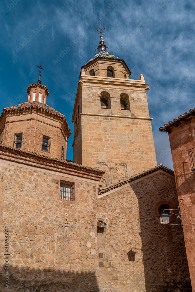 View of the cathedral de salvador catholic church in Albarracin Spain behind the arches of the municipality building