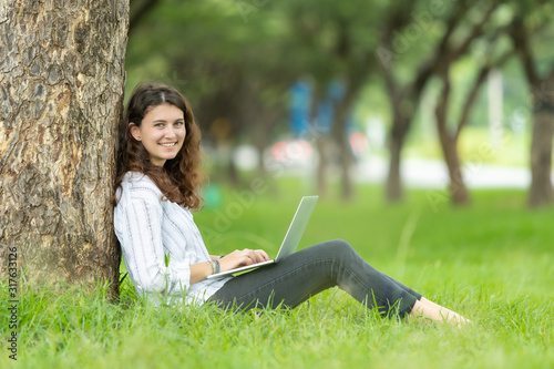 Picture of happy young woman so cute be smile working with her laptop in the park outdoors 
