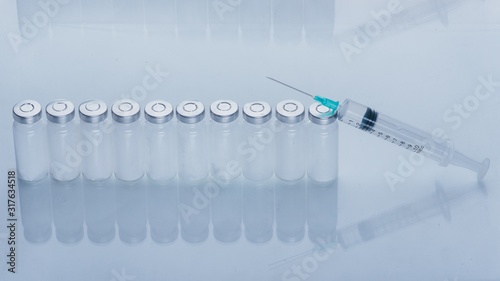 Medicine  Injection  vaccine and disposable syringe  drug concept. Sterile vial medical syringe needle. Macro close up. Glass medical ampoule vial for injection. Bottles ampule with aluminum cap.