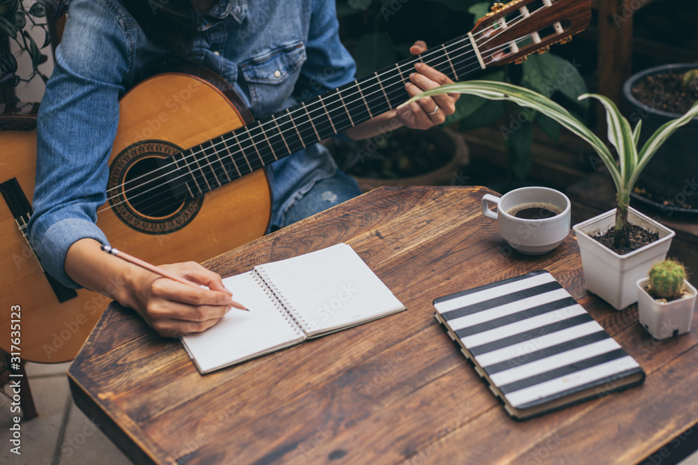 Fototapeta premium artist songwriter thinking writing notes,lyrics in book at studio.man playing live acoustic guitar relax chill.concept for musician creative.composer work process.people relaxing time with instrument