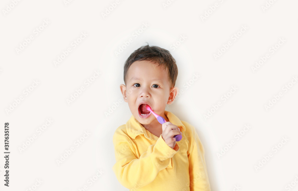 Adorable little Asian boy brushing teeth over white background. Adorable little Asian boy brushing teeth over white background.