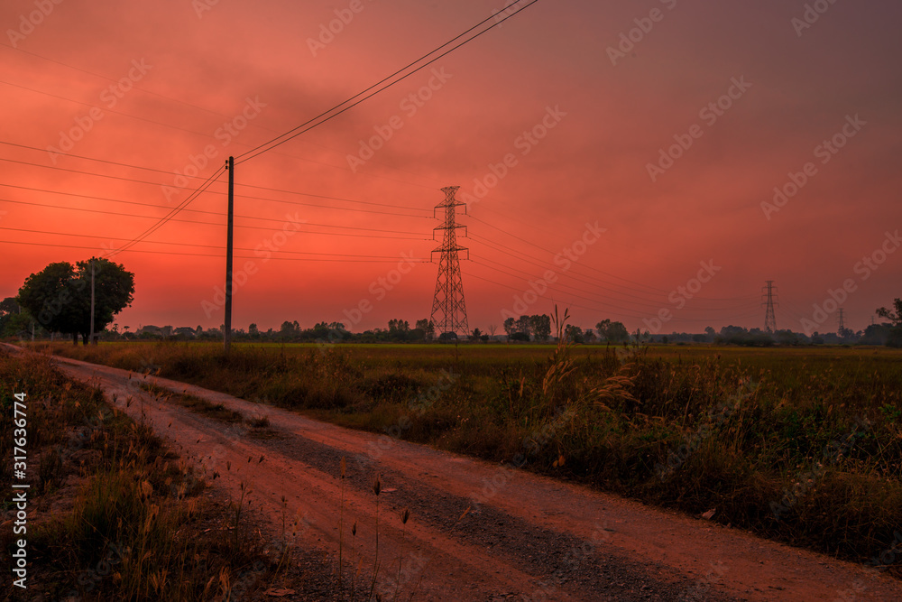 Blurred twilight evening background on rice paddies, with high voltage electricity towers passing through, cool and fresh air while traveling