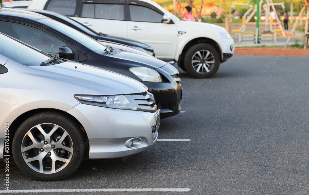 Closeup of front side of bronze, silver car and other cars parking in outdoor parking lot in the evening. Closeup of front side of bronze, silver car and other cars parking in outdoor parking lot in the evening.