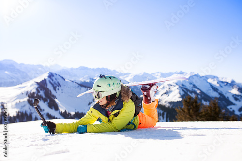 snowboarded girl posing on the snow with action camera