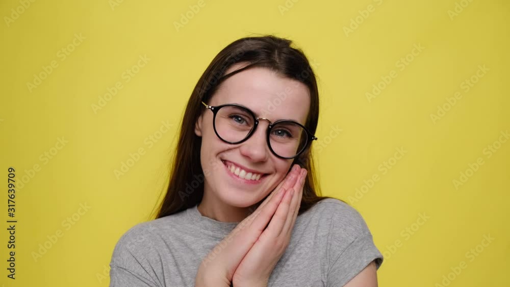 Closeup portrait woman in glasses looking surprised in full disbelief wide open mouth and clapping his hands isolated yellow background. Positive human emotion facial expression body language Closeup portrait woman in glasses looking surprised in full disbelief wide open mouth and clapping his hands isolated yellow background. Positive human emotion facial expression body language
