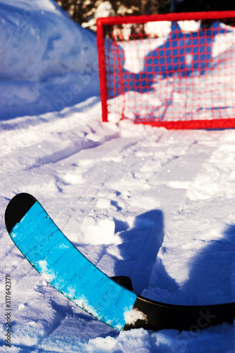 Shot the puck into the red hockey goal with a composite stick with a blue ribbon. Winter games and sports in the backyard photo