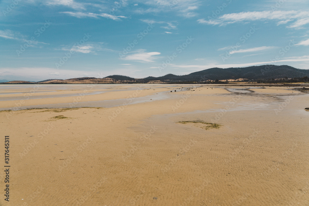 view of Dunalley Beach in Tasmania, Australia with sandbanks and shallow pristine water view of Dunalley Beach in Tasmania, Australia with sandbanks and shallow pristine water