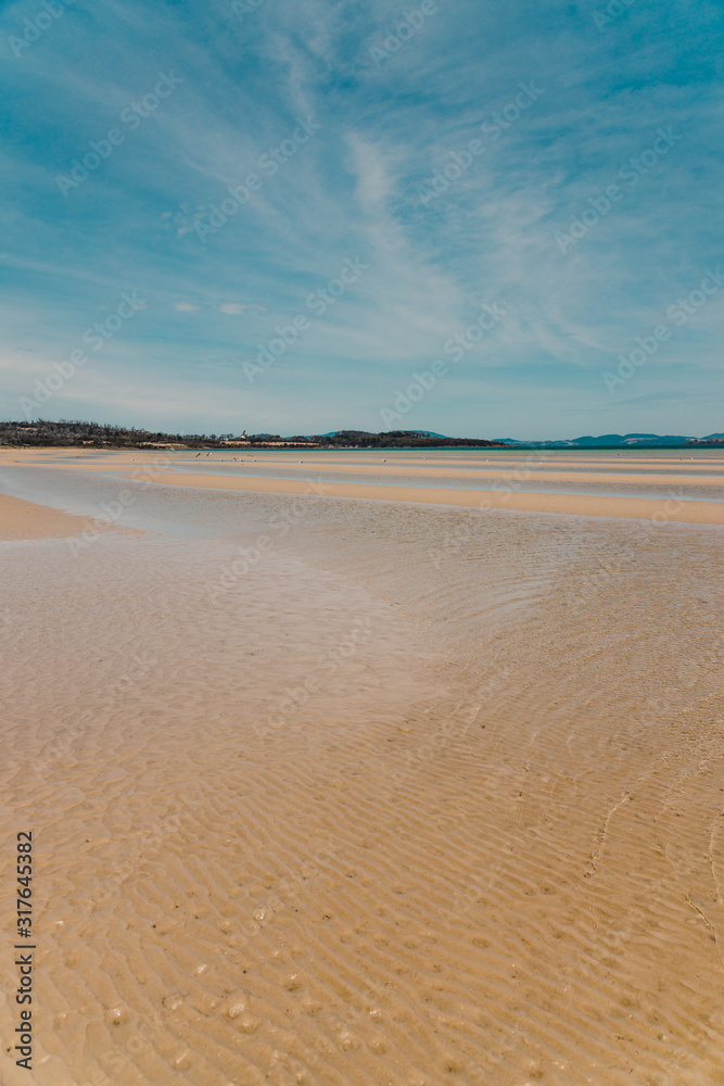 view of Dunalley Beach in Tasmania, Australia with sandbanks and shallow pristine water view of Dunalley Beach in Tasmania, Australia with sandbanks and shallow pristine water