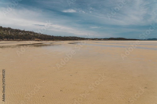 view of Dunalley Beach in Tasmania, Australia with sandbanks and shallow pristine water