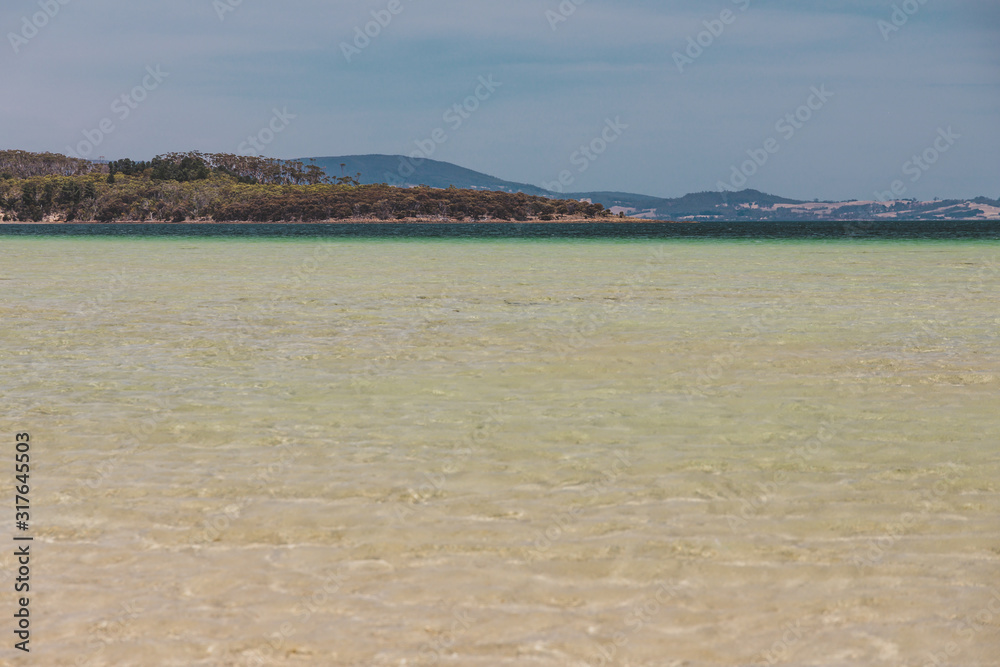 view of Dunalley Beach in Tasmania, Australia with sandbanks and shallow pristine water