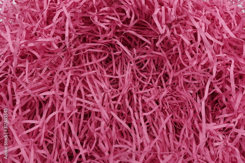 Close up of pink paper strips from shredder full frame for background and texture.