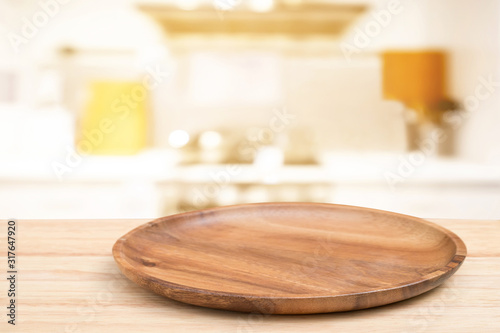 Empty wooden tray on perspective wooden table on top over blur flower background. Can be used mock up for montage products display or design layout. photo