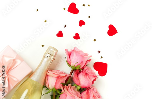 Fototapeta Naklejka Na Ścianę i Meble -  Valentine's day, birthday background. Bouquet of pink roses flowers, gift box ,champagne bottle and red hearts confetti isolated on white background with copy space. Top view flat lay