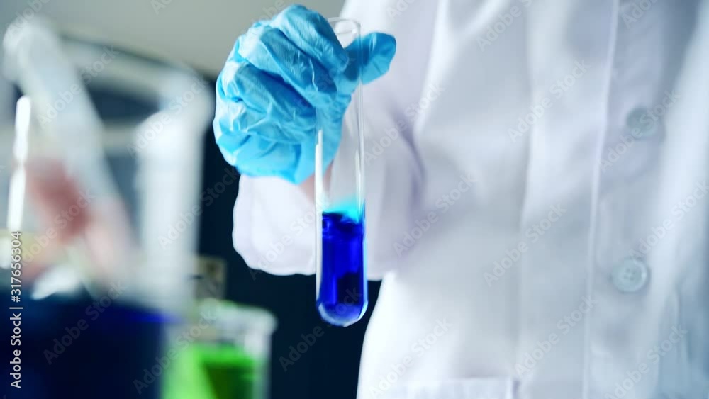 closeup Hand test equipment for science experiments oil pouring scientist with test tube making