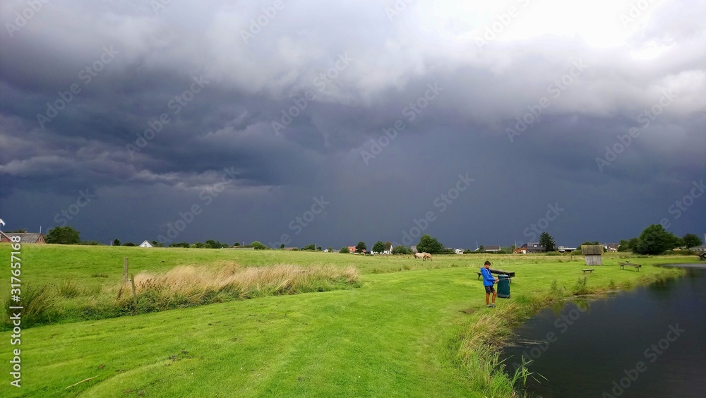 dramatic storm forming over a lush green meadow dramatic storm forming over a lush green meadow
