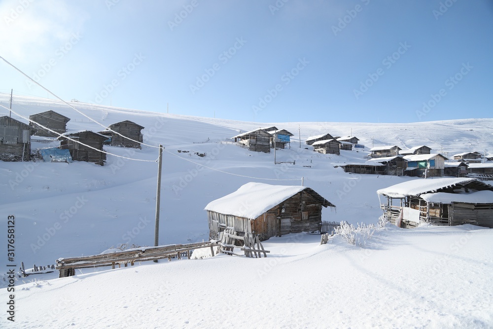mountain landscape slopes covered with snow can be seen a tree fence and a house.savsat/artvin