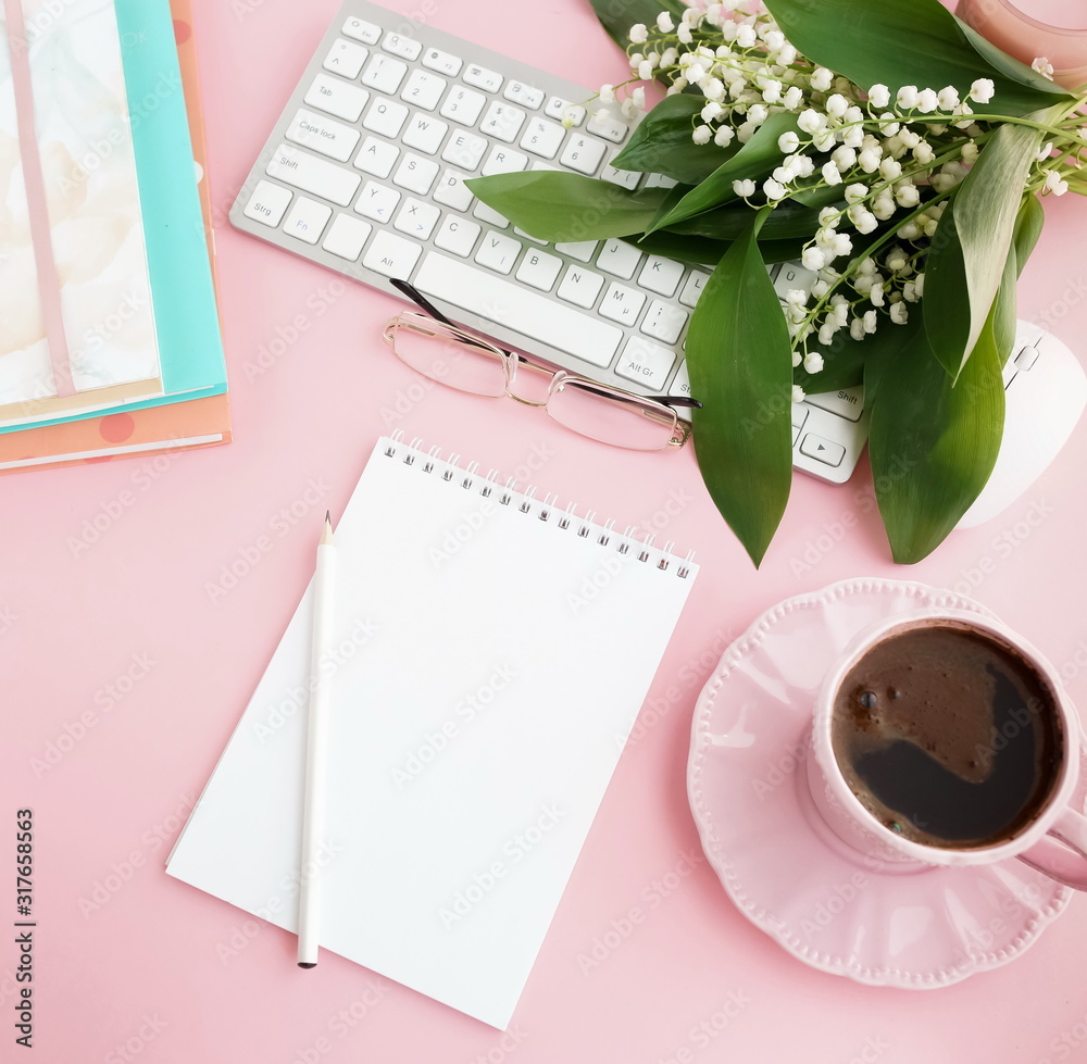 Pink flat lay top view women's office desk . Female workspace with laptop, white spring flowers lilies, accessories, notebooks mock up, glasses, cup of coffee on pale pink background. Copy space Pink flat lay top view women's office desk . Female workspace with laptop, white spring flowers lilies, accessories, notebooks mock up, glasses, cup of coffee on pale pink background. Copy space