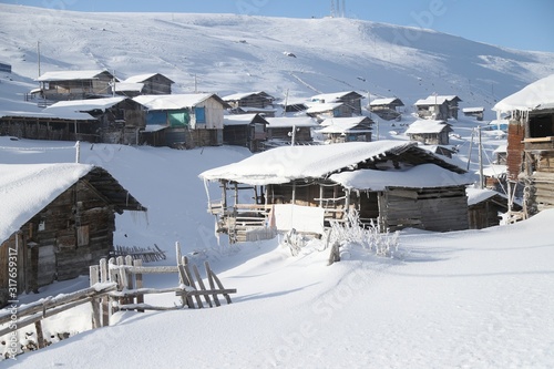 mountain landscape slopes covered with snow can be seen a tree fence and a house.savsat/artvin © murat