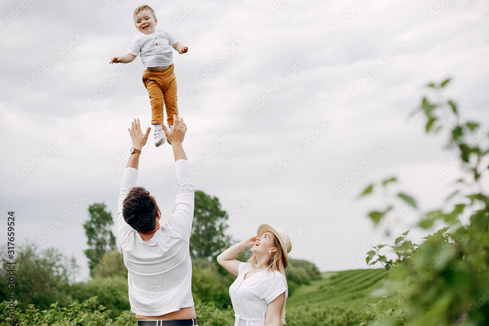 Fototapeta premium Family with cute little son. Father in a white t-shirt. Lady in a white dress