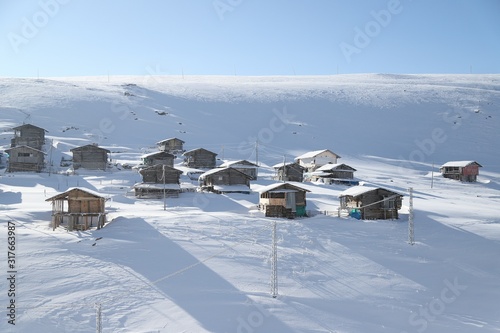 mountain landscape slopes covered with snow can be seen a tree fence and a house.savsat/artvin