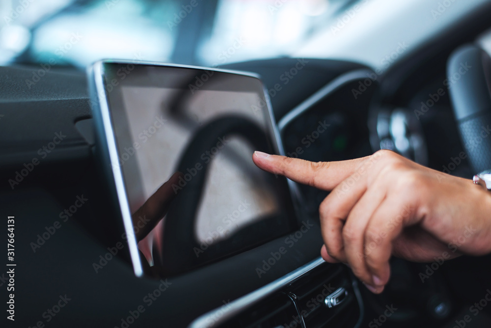 Male hand touching screen in modern car.
