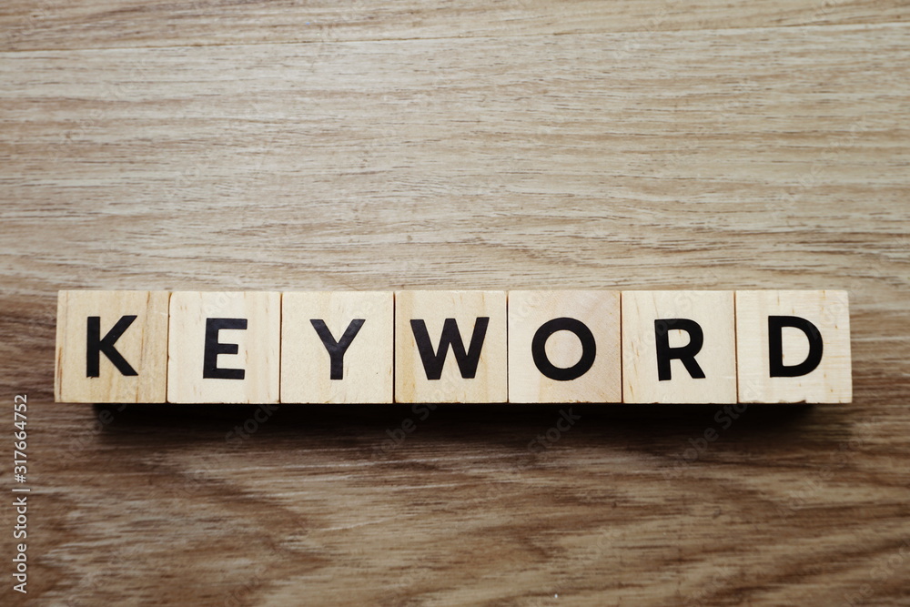 Fototapeta premium Słowo kluczowe litera alfabetu na drewnianym tle