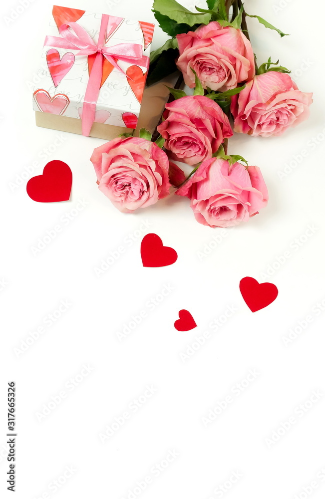 Bouquet of pink roses flowers, gift box  and red hearts confetti isolated  on white background with copy space. Holiday, Valentine's day, birthday backdrop. Top view. flat lay